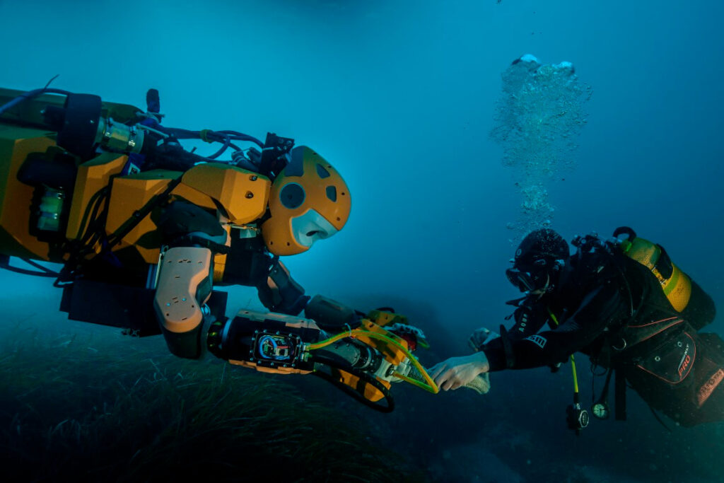 Robot submarino explorando el fondo marino con luces y cámaras activadas.