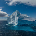 Iceberg gigante sobre el mar azul en un día despejado
